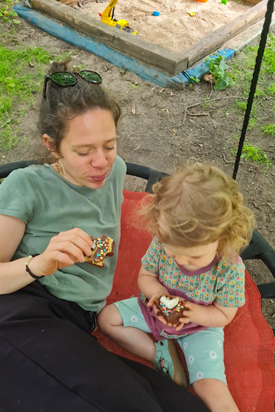 tereza-kreim-075 Frau und Kind sitzen auf einer Schaukel und essen Kuchen.